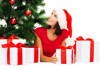 Image showing smiling woman in santa helper hat with gift boxes