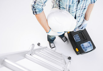 Image showing man with ladder, helmet and toolkit