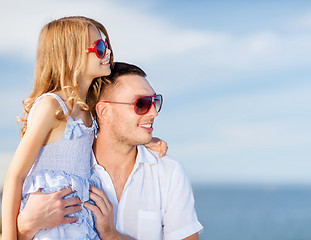 Image showing happy father and child in sunglasses over blue sky