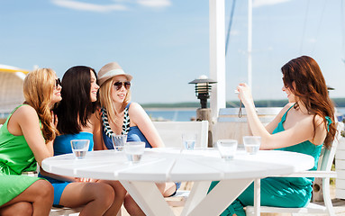 Image showing girls taking photo in cafe on the beach