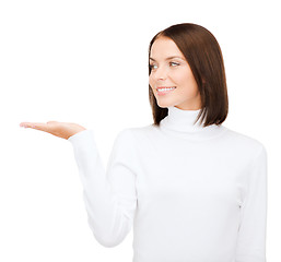 Image showing woman in white sweater with something on palm