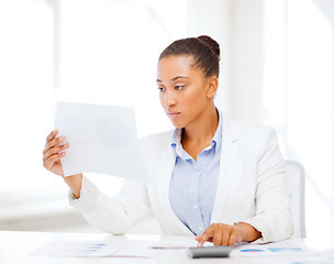 Image showing businesswoman working with calculator in office