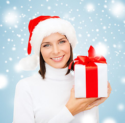 Image showing smiling woman in santa helper hat with gift box