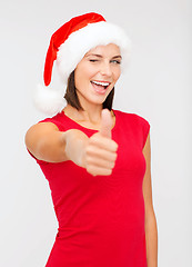 Image showing woman in santa helper hat showing thumbs up