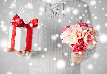 Image showing man holding bouquet of flowers and gift box