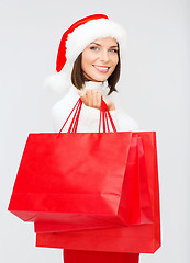 Image showing woman in santa helper hat with shopping bags