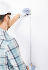 Image showing architect measuring wall with flexible ruler