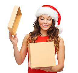 Image showing smiling woman in santa helper hat with gift box