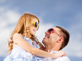 Image showing happy father and child in sunglasses over blue sky