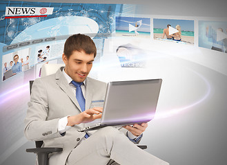 Image showing businessman with laptop pc reading news