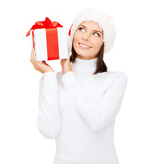 Image showing smiling woman in santa helper hat with gift box