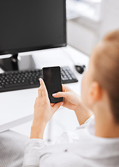 Image showing businesswoman with smartphone in office