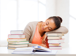 Image showing tired student with books and notes