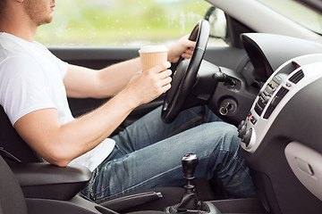 Image showing man drinking coffee while driving the car