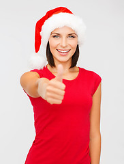 Image showing woman in santa helper hat showing thumbs up