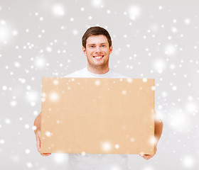 Image showing smiling man carrying carton box