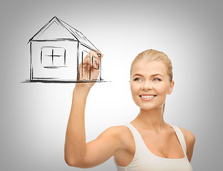 Image showing woman drawing house on virtual screen