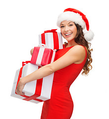 Image showing woman in santa helper hat with many gift boxes