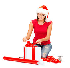 Image showing smiling woman in santa helper hat with gift box