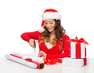 Image showing smiling woman in santa helper hat with gift box