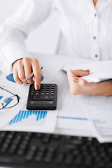 Image showing woman hand with calculator and papers