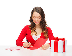 Image showing smiling woman in red clothes with postcard