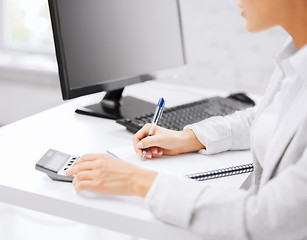 Image showing businesswoman with notebook and calculator