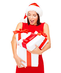 Image showing woman in santa helper hat with many gift boxes