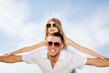 Image showing happy father and child in sunglasses over blue sky