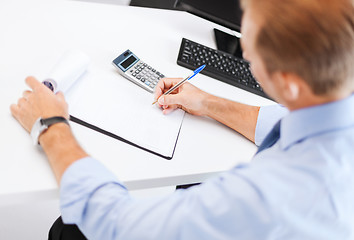 Image showing businessman with notebook and calculator