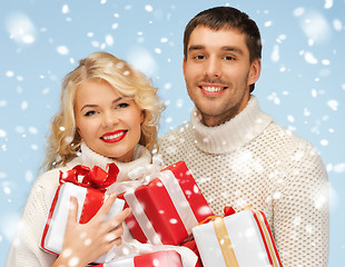 Image showing happy man and woman with many gift boxes