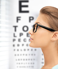 Image showing woman in eyeglasses with eye chart