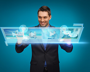 Image showing businessman pressing buttons on virtual screen