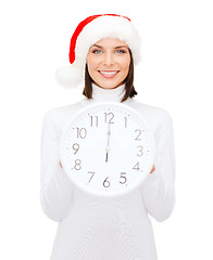 Image showing woman in santa helper hat with clock showing 12