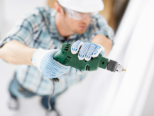 Image showing man drilling the wall