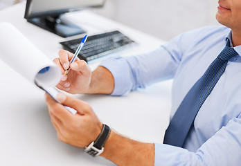 Image showing businessman working and signing papers