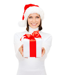 Image showing smiling woman in santa helper hat with gift box