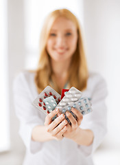 Image showing female doctor with packs of pills