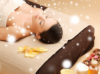 Image showing woman in spa salon lying on the massage desk