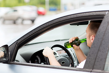 Image showing man drinking alcohol while driving the car