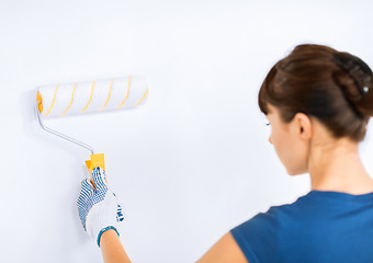 Image showing woman with roller and paint colouring the wall