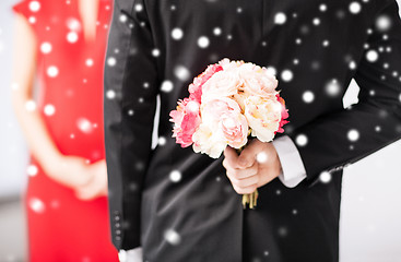 Image showing man hiding bouquet of flowers