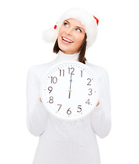 Image showing woman in santa helper hat with clock showing 12