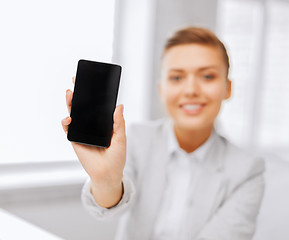 Image showing businesswoman with smartphone in office