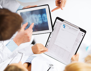 Image showing group of doctors looking at x-ray on tablet pc