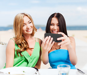Image showing girls taking photo in cafe on the beach