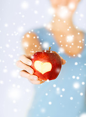 Image showing woman hand holding red apple with heart shape