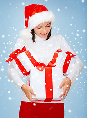 Image showing woman in santa helper hat with many gift boxes