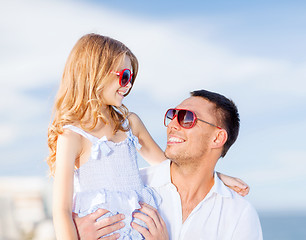 Image showing happy father and child in sunglasses over blue sky