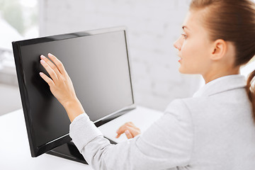 Image showing smiling businesswoman with touchscreen in office